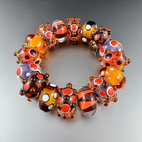 Lampwork glass bead set of 16 in rich fall colors, ambers, reds, corals and maroon